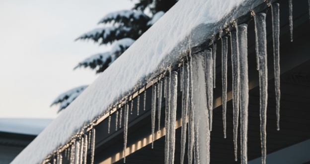 Gutter guards and icicles on snowy roof winter