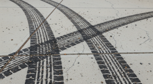 Tire marks on concrete driveway before cleaning